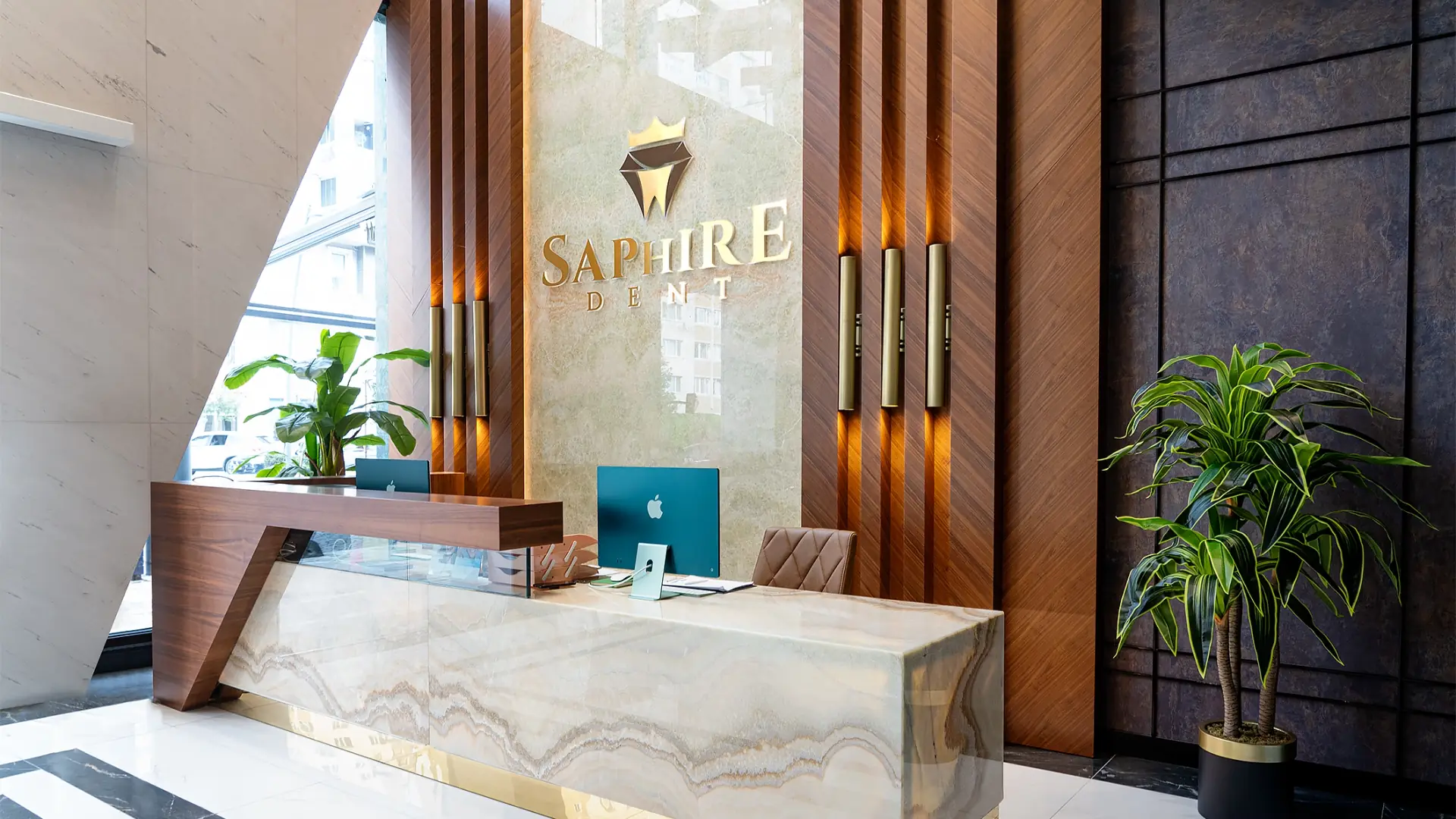 The Saphiredent reception desk, with the clinic's gold sign on a marble wall